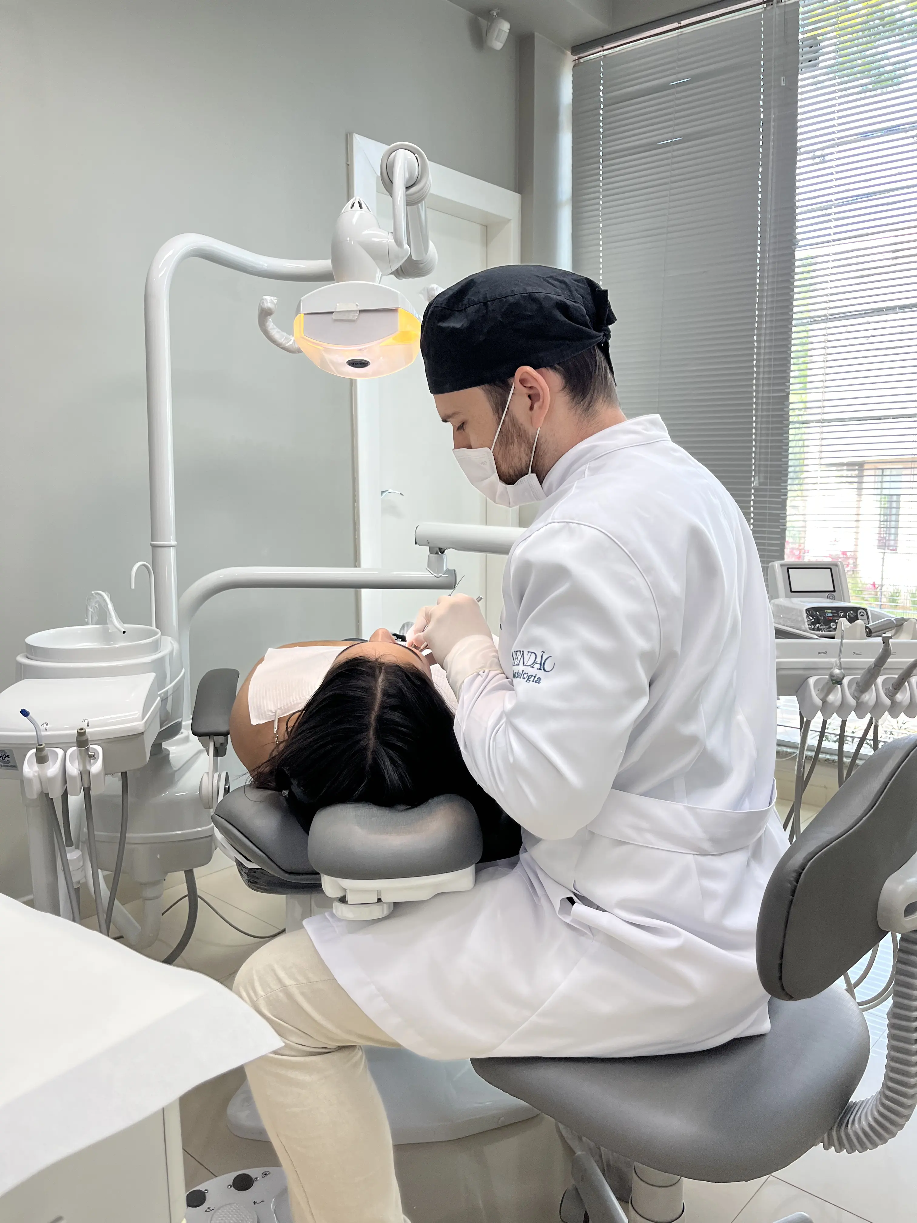 Dentista a atender paciente a sorrir